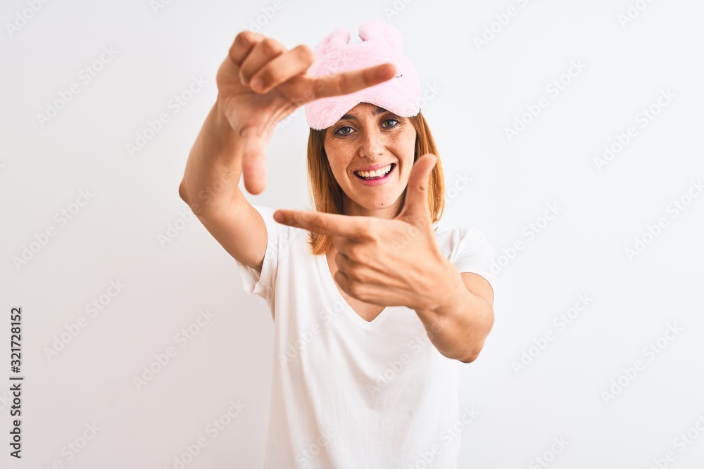 Beautiful redhead woman wearing sleeping mask over isolated background smiling making frame with hands and fingers with happy face. Creativity and photography concept. Beautiful redhead woman wearing sleeping mask over isolated background smiling making frame with hands and fingers with happy face. Creativity and photography concept.
