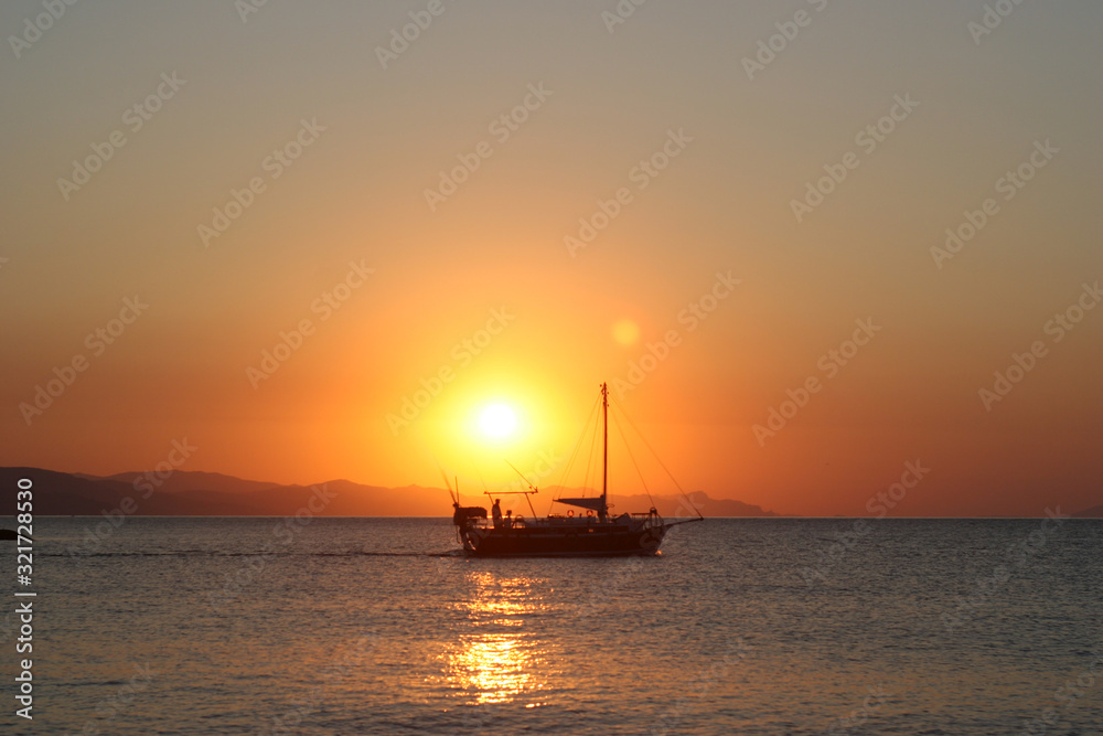 The boat with the sun appearing on the background