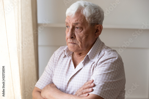Lonely old man look in window thinking