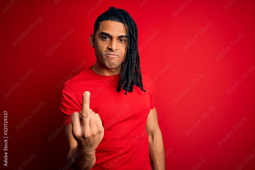 Young handsome african american afro man with dreadlocks wearing red casual t-shirt Showing middle finger, impolite and rude fuck off expression Young handsome african american afro man with dreadlocks wearing red casual t-shirt Showing middle finger, impolite and rude fuck off expression