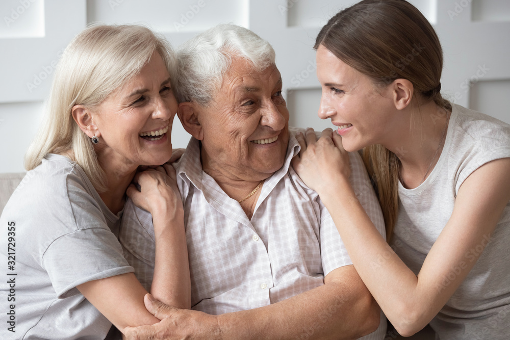 Portrait of happy elderly parents and adult daughter hugging Portrait of happy elderly parents and adult daughter hugging