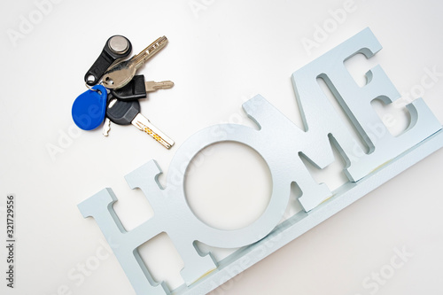 A bunch, set of metal keys and a home sign on white background