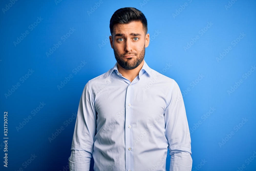 Young handsome man wearing elegant shirt standing over isolated blue background depressed and worry for distress, crying angry and afraid. Sad expression. Young handsome man wearing elegant shirt standing over isolated blue background depressed and worry for distress, crying angry and afraid. Sad expression.