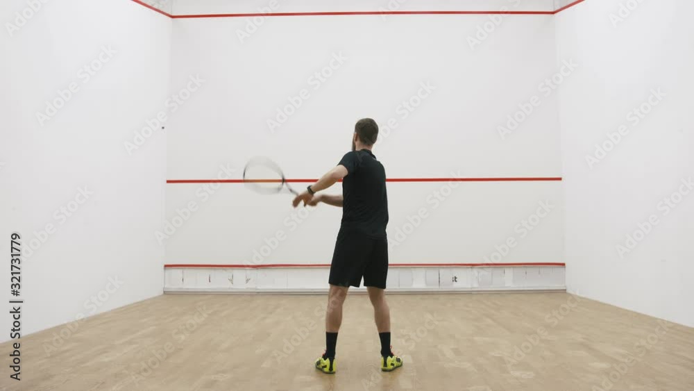 A portrait of a young bearded man practicing to play squash, slow motion A portrait of a young bearded man practicing to play squash, slow motion