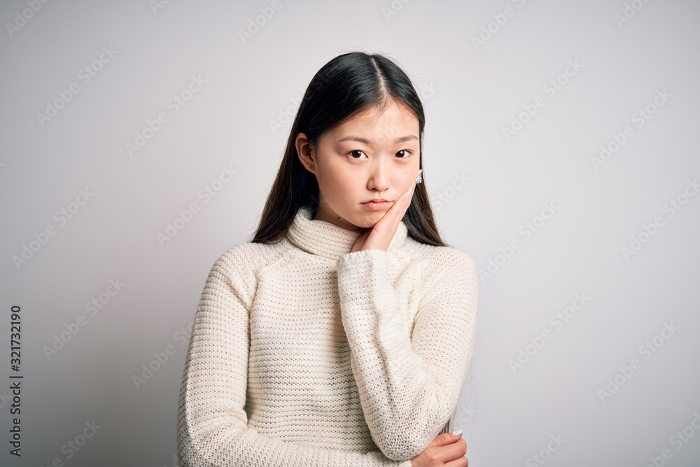 Young beautiful asian woman wearing casual sweater standing over isolated background thinking looking tired and bored with depression problems with crossed arms. Young beautiful asian woman wearing casual sweater standing over isolated background thinking looking tired and bored with depression problems with crossed arms.