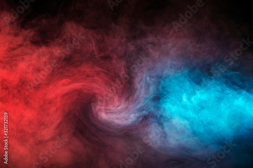 Abstract texture of backlit smoke in red blue on a black background.
