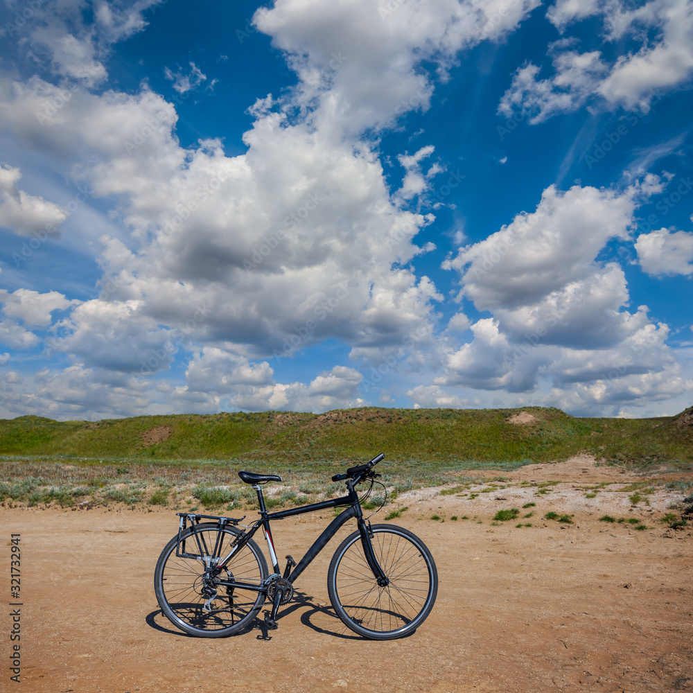 Fototapeta premium closeup bicycle on a sandy sea beach under a cloudy sky