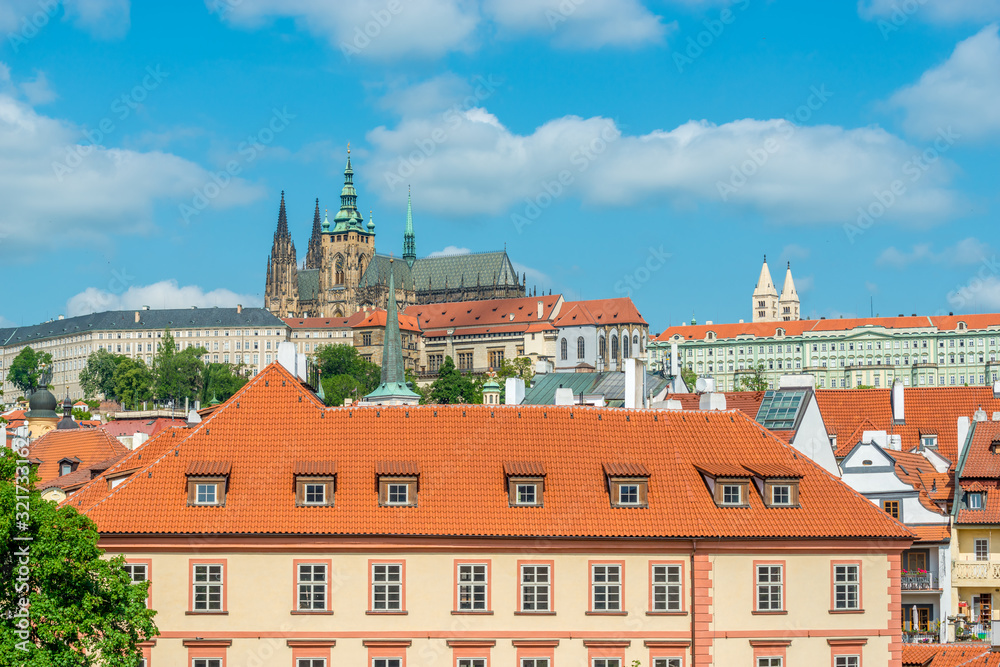 Obraz premium Top view to red roofs and blue sky skyline of Prague city Czech republic.