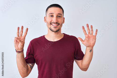 Young handsome man standing over isolated background showing and pointing up with fingers number eight while smiling confident and happy.