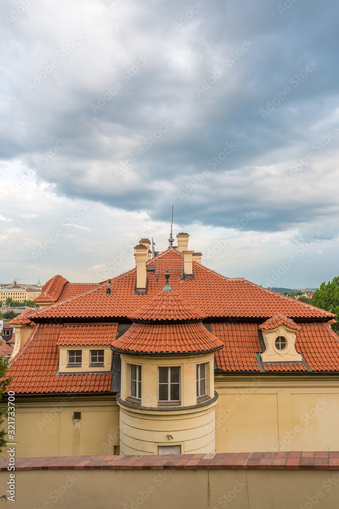 View of the top of old buildings with red roof and dramatic sky at Prague city Czech republic.