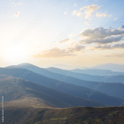 mountain ridge silhouette in a blue mist at sunrise