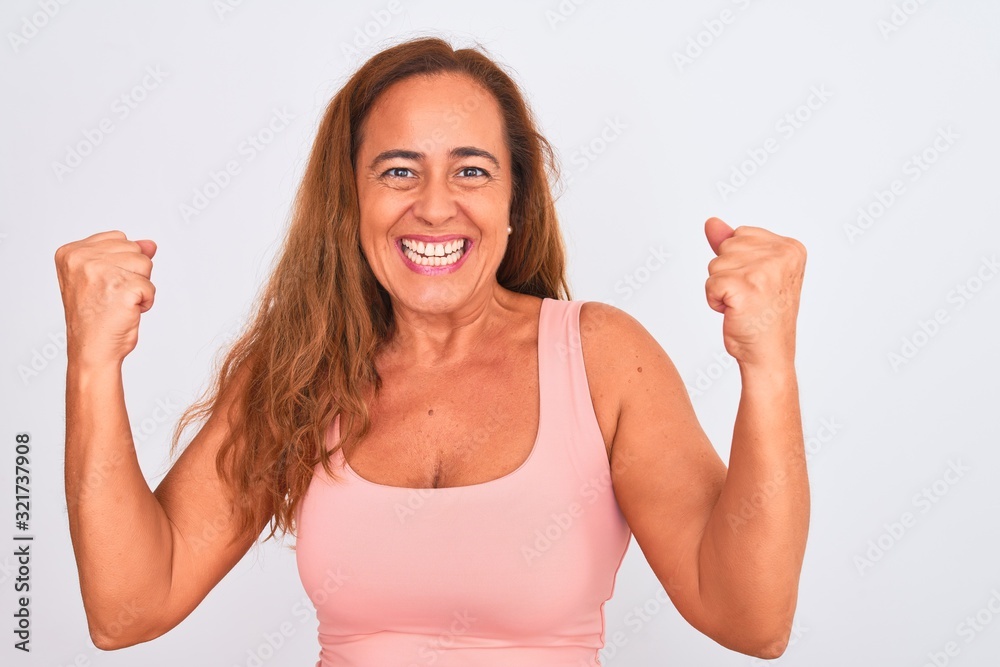 Fototapeta premium Middle age mature woman standing over white isolated background screaming proud and celebrating victory and success very excited, cheering emotion
