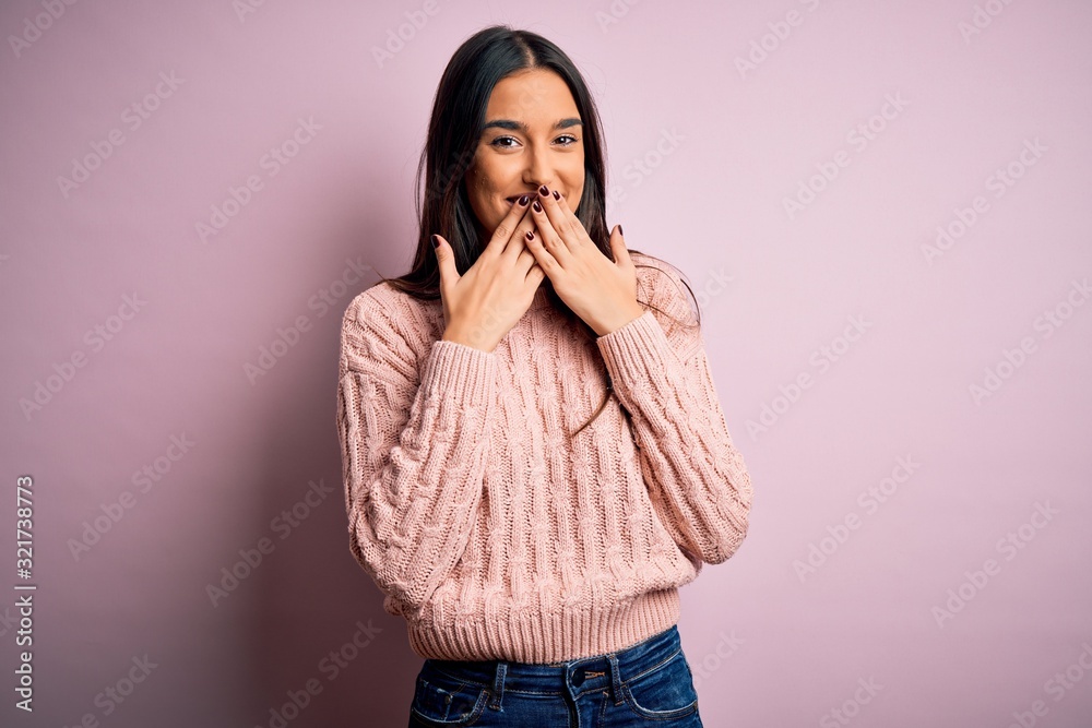Young beautiful brunette woman wearing casual sweater over isolated pink background laughing and embarrassed giggle covering mouth with hands, gossip and scandal concept Young beautiful brunette woman wearing casual sweater over isolated pink background laughing and embarrassed giggle covering mouth with hands, gossip and scandal concept