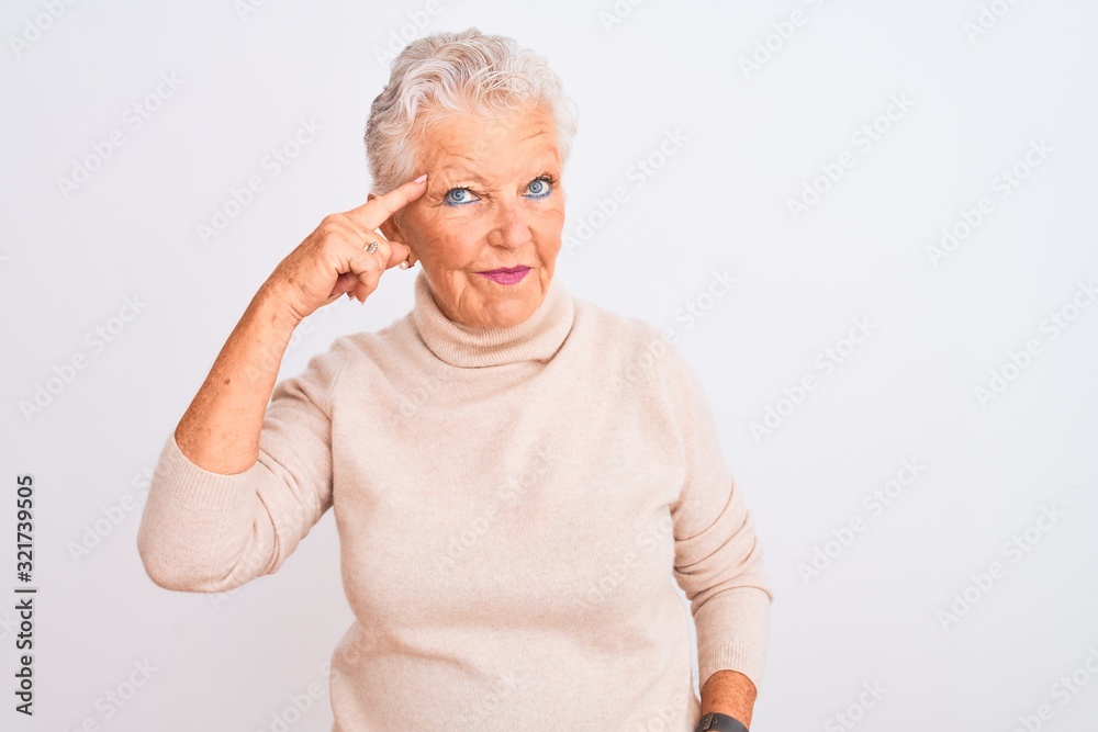 Senior grey-haired woman wearing turtleneck sweater standing over isolated white background Smiling pointing to head with one finger, great idea or thought, good memory Senior grey-haired woman wearing turtleneck sweater standing over isolated white background Smiling pointing to head with one finger, great idea or thought, good memory