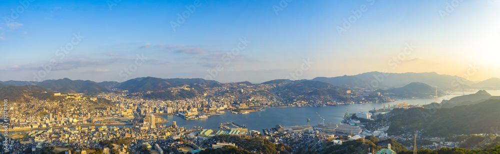 Nagasaki cityscape panorama view from Mt Inasa observation platform deck in sunny day sunset time with blue sky background, famous beauty scenic spot in the world. Nagasaki Prefecture, Japan