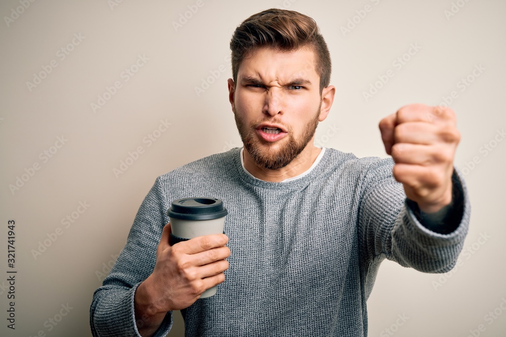 Young blond man with beard and blue eyes drinking cup of coffee over white background annoyed and frustrated shouting with anger, crazy and yelling with raised hand, anger concept Young blond man with beard and blue eyes drinking cup of coffee over white background annoyed and frustrated shouting with anger, crazy and yelling with raised hand, anger concept