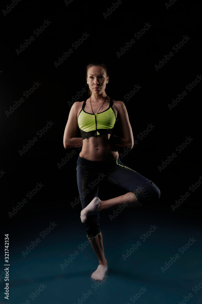 girl in sportswear is engaged in yoga in a certain position
