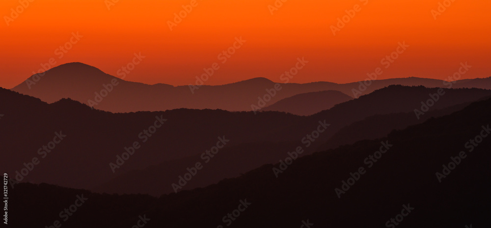 Haze Separates Layers of Orange Mountains