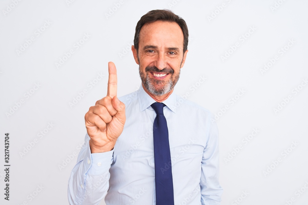 Middle age businessman wearing elegant tie standing over isolated white background showing and pointing up with finger number one while smiling confident and happy. Middle age businessman wearing elegant tie standing over isolated white background showing and pointing up with finger number one while smiling confident and happy.