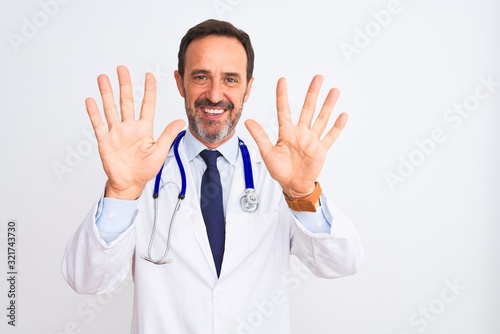 Middle age doctor man wearing coat and stethoscope standing over isolated white background showing and pointing up with fingers number ten while smiling confident and happy. © Krakenimages.com