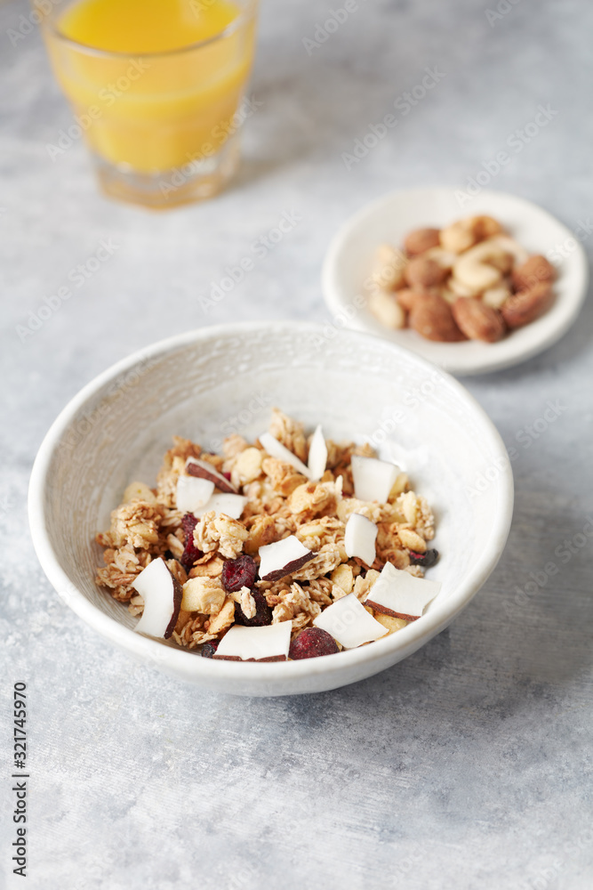 Bowl of granola with nuts, cranberry and cocoanut. Concept for a tasty and healthy meal. Stone background. Bowl of granola with nuts, cranberry and cocoanut. Concept for a tasty and healthy meal. Stone background.