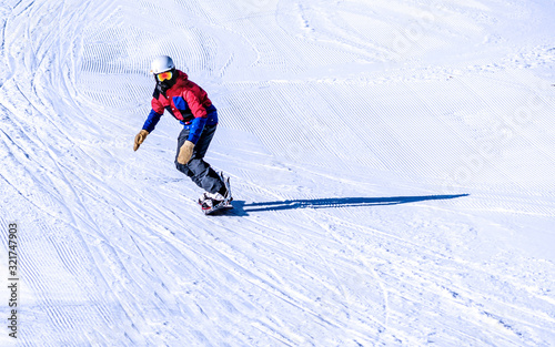 People are enjoying downhill skiing and snowboarding 
