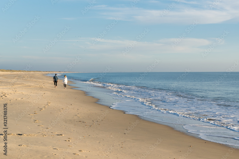 Almonte, España, February 2, 2020: Couple walking on the beach with blue sky