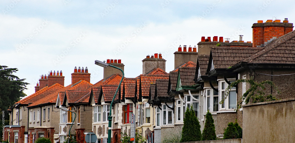 Fototapeta premium Fasady i kominy typowych kamienic w Dublinie w Irlandii