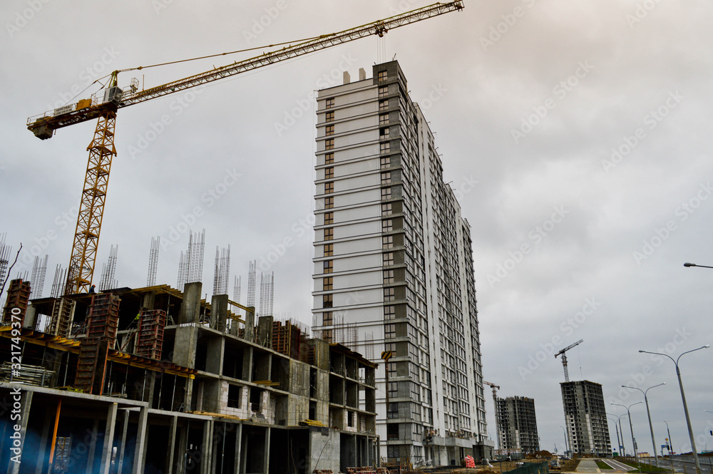 Construction of large modern monolithic frame houses, buildings using industrial construction equipment and large high cranes. Construction of the building in the new micro district of the city Construction of large modern monolithic frame houses, buildings using industrial construction equipment and large high cranes. Construction of the building in the new micro district of the city