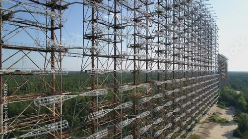 Aerial view of the DUGA radar station near the city of Chernobyl-2 among the forest. Exclusion Zone. Camera pans left. 4K drone footage. photo