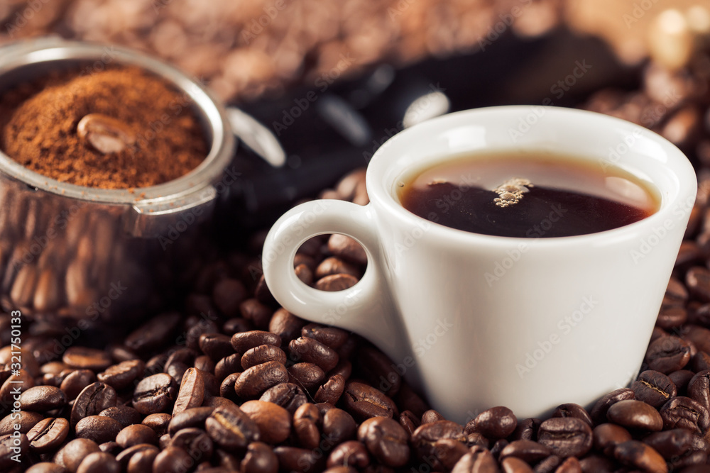 Obraz premium Ground coffee and coffee beans on old cafe table.