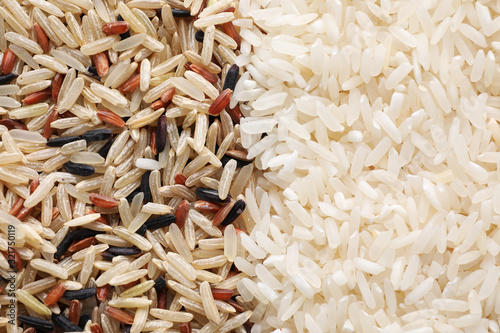 Brown and polished rice as background, top view photo