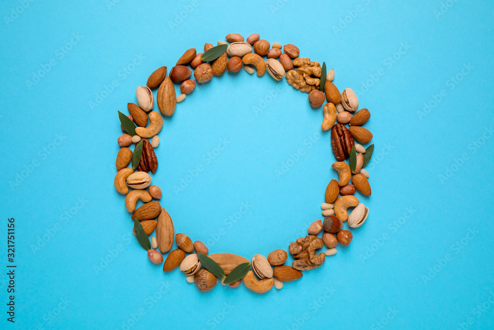 Obraz premium Different delicious nuts on light blue background, flat lay. Space for text