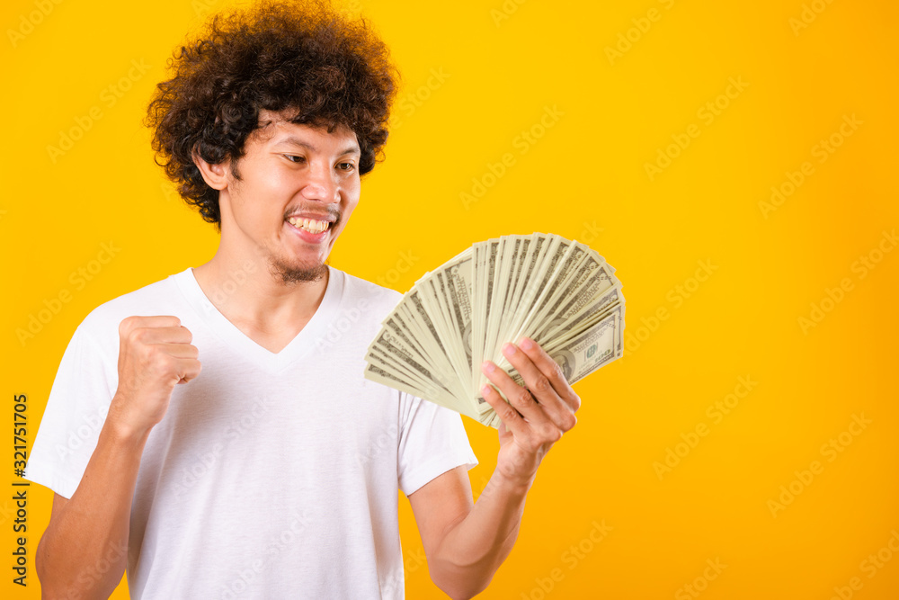 Asian handsome man with curly hair holding fans of money dollar bills Asian handsome man with curly hair holding fans of money dollar bills
