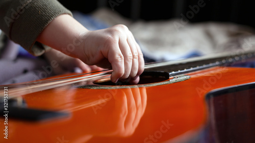 little girl tries to tear the strings on the guitar