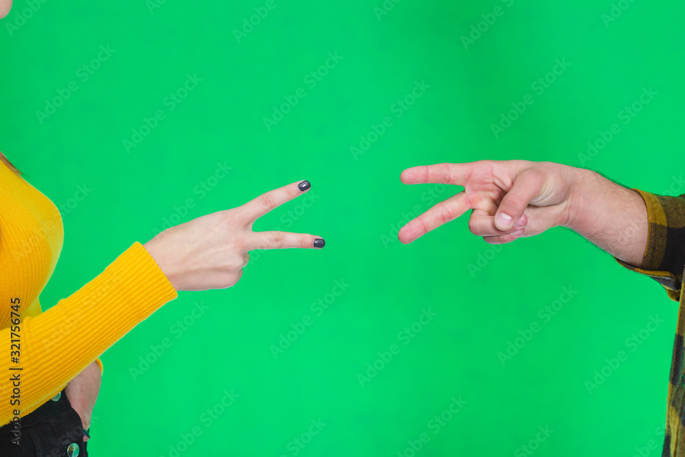 Cropped hands of people playing rock paper scissors isolated on green background. Cropped hands of people playing rock paper scissors isolated on green background.
