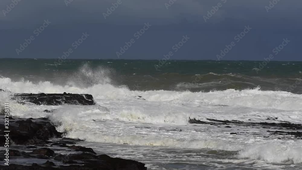 Waves from the Southern Ocean crashing into the rocky headland between Porpoise and Curio Bays. In the Catlins, Southland, New Zealand. Waves from the Southern Ocean crashing into the rocky headland between Porpoise and Curio Bays. In the Catlins, Southland, New Zealand.