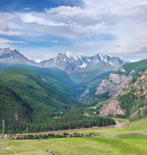 Summer landscape, scenic mountains. Summer greens with snow-capped mountains. Travel in the mountains of Altai.