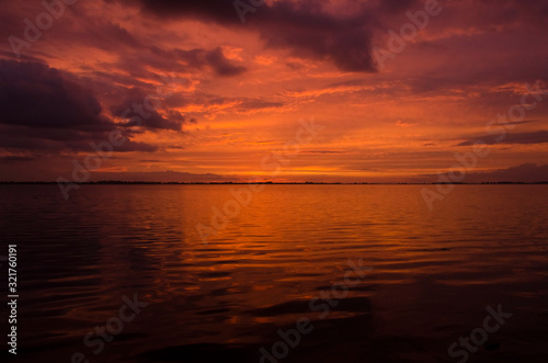 Sunset over Lake Chascomus  orange beautiful sky reflected in the water surface