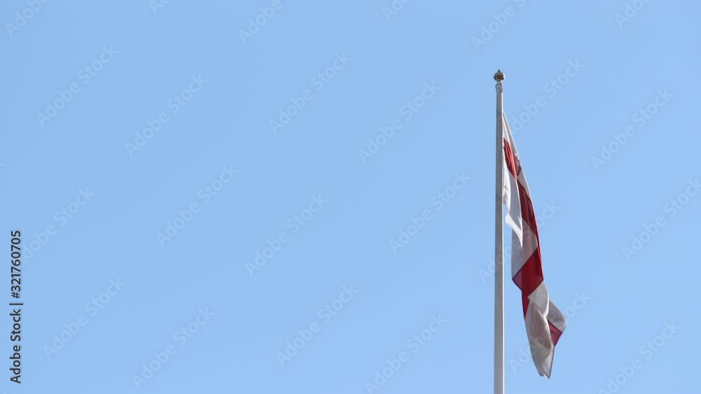 Low angle shot of the flag of London flying in a breeze before a blue sky Low angle shot of the flag of London flying in a breeze before a blue sky