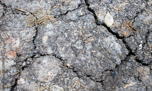 Soil or ground with several cracks due to drought or dryness caused by heat or global warming or climate change effecting the agriculture and farm