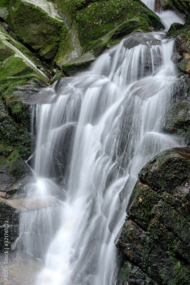 Fototapeta premium Waterfall with stones covered by moss in a forest (Uguisu's falls in Nara, Japan)