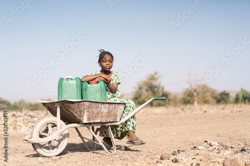 Cheerful West Africa Women Transporting Tap Water in a typical village