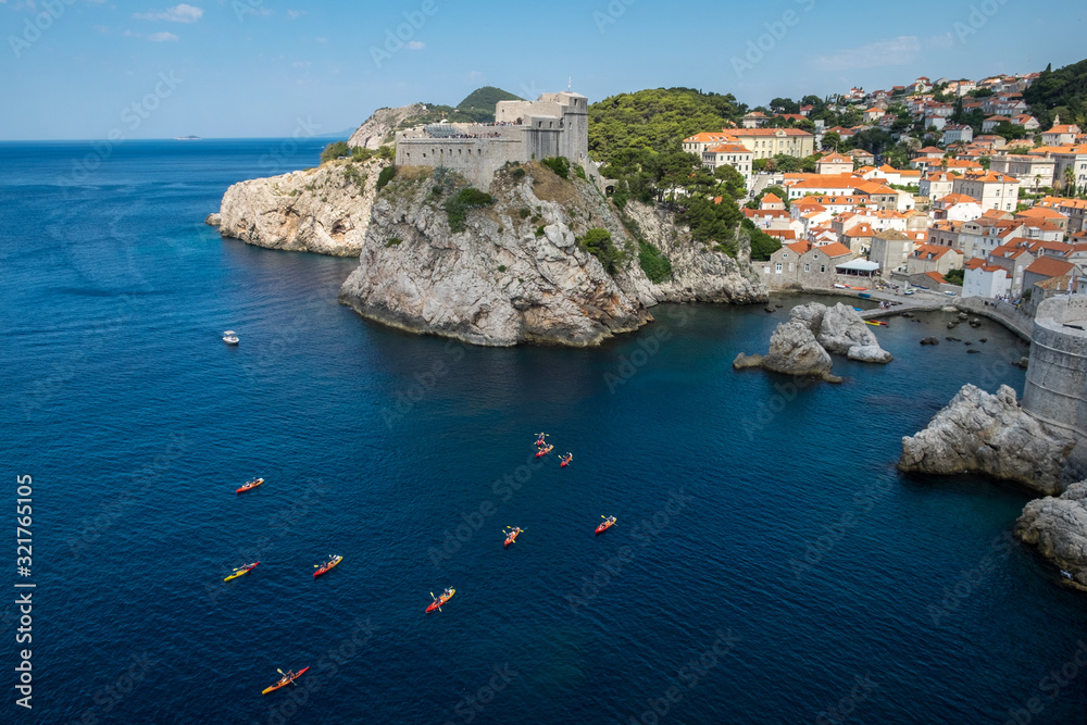 Old Town houses with red tiled roofs and rocky green idyllic island in background, Dubrovnik, Dalmatia, Croatia