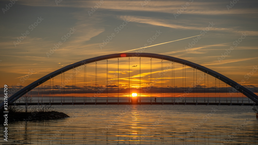 sunrise behind bridge with plane sunrise behind bridge with plane