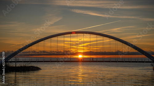 sunrise behind bridge with plane © Lance