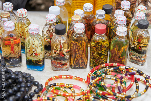 Close-up view of colorful plastic arm rings and glass bottles filled with spiritual content for sale by indigenous aeta vendors in the Philippines photo