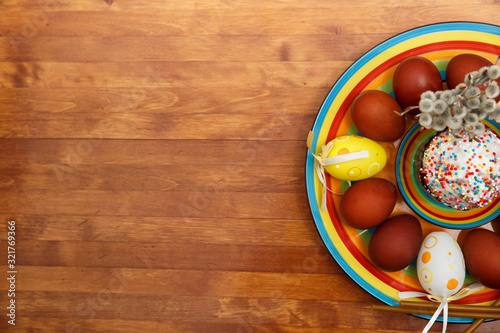 Easter cake with painted eggs on a table made of natural wood.