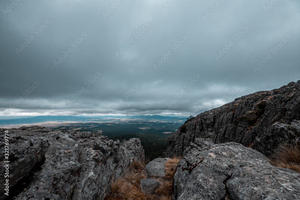 Forest landscape, on a rocky mountain, rain clouds are seen in the background with a storm over the trees 3 Forest landscape, on a rocky mountain, rain clouds are seen in the background with a storm over the trees 3