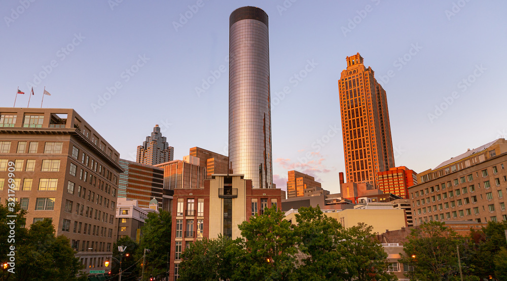 Downtown Atlanta Skyline showing several prominent buildings, apartments, offices and hotels under a blue sky.